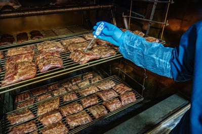 Grilled barbecue pork ribs in a smoker at the factory.