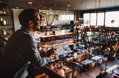 happy-businessman-restaurant-owner-proudly-looking-at-crowded-restaurant