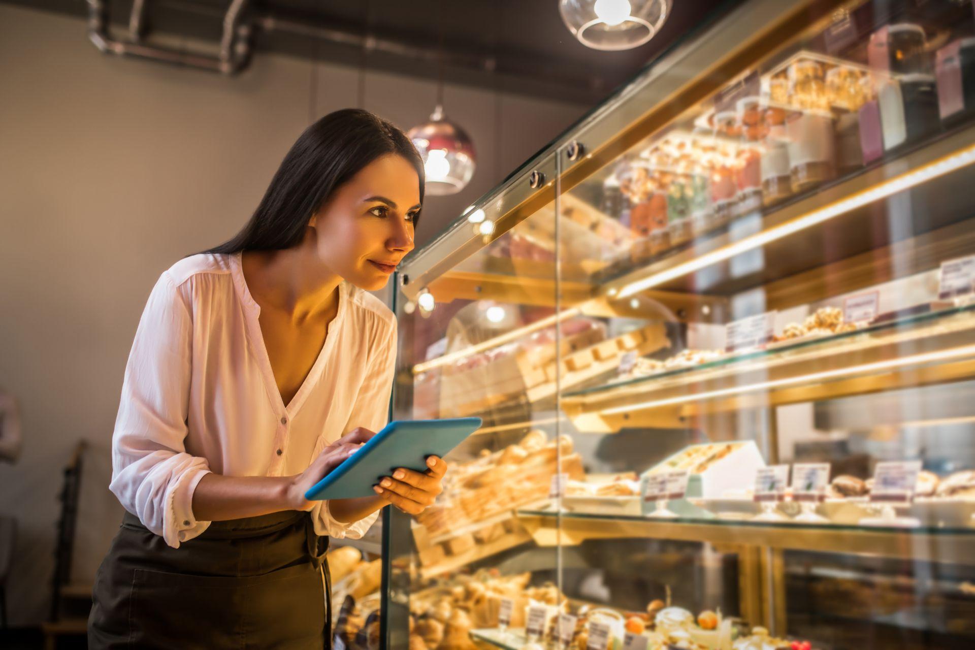 Businesswoman holding tablet while ordering foods for bakery
