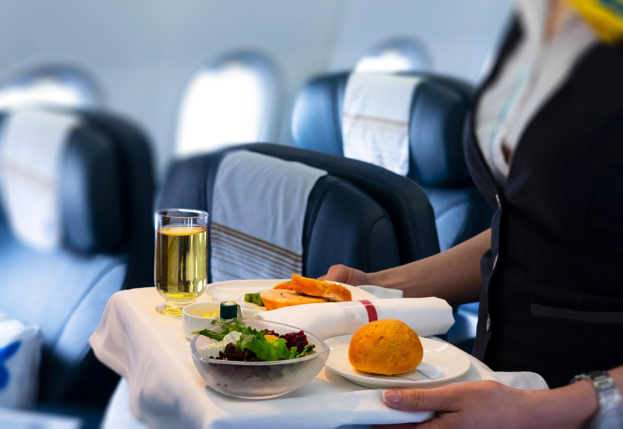 Flight attendant serving meal in an airplane