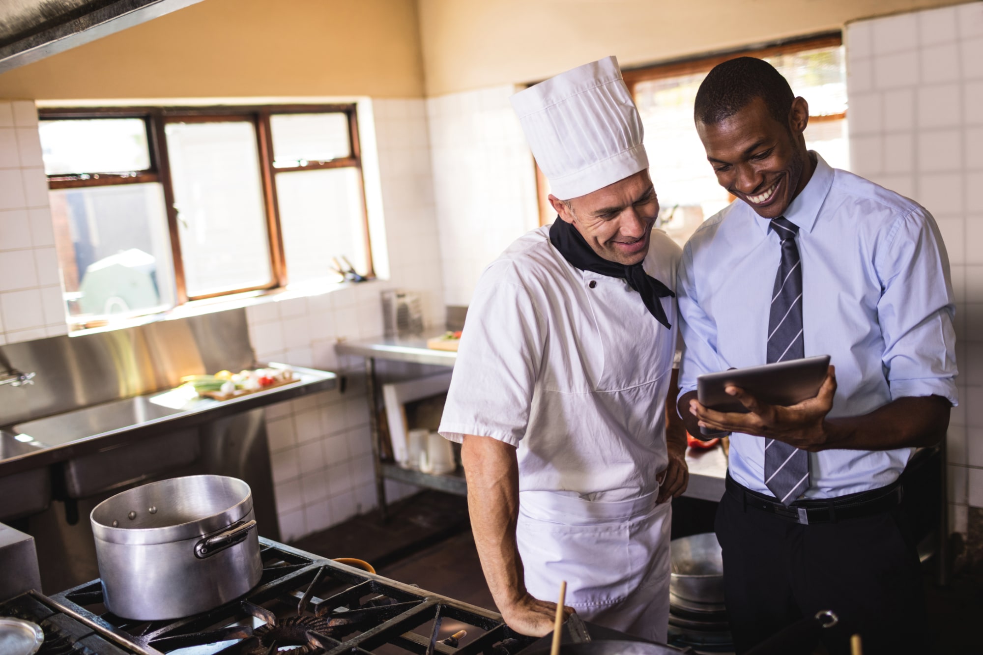 male-manager-and-chef-using-digital-tablet-in-kitchen