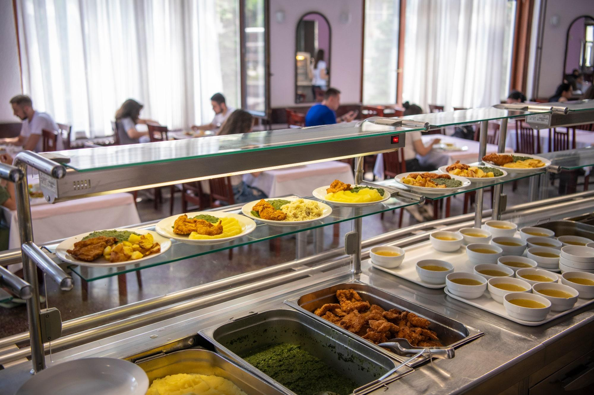 Students being served meal in school canteen.