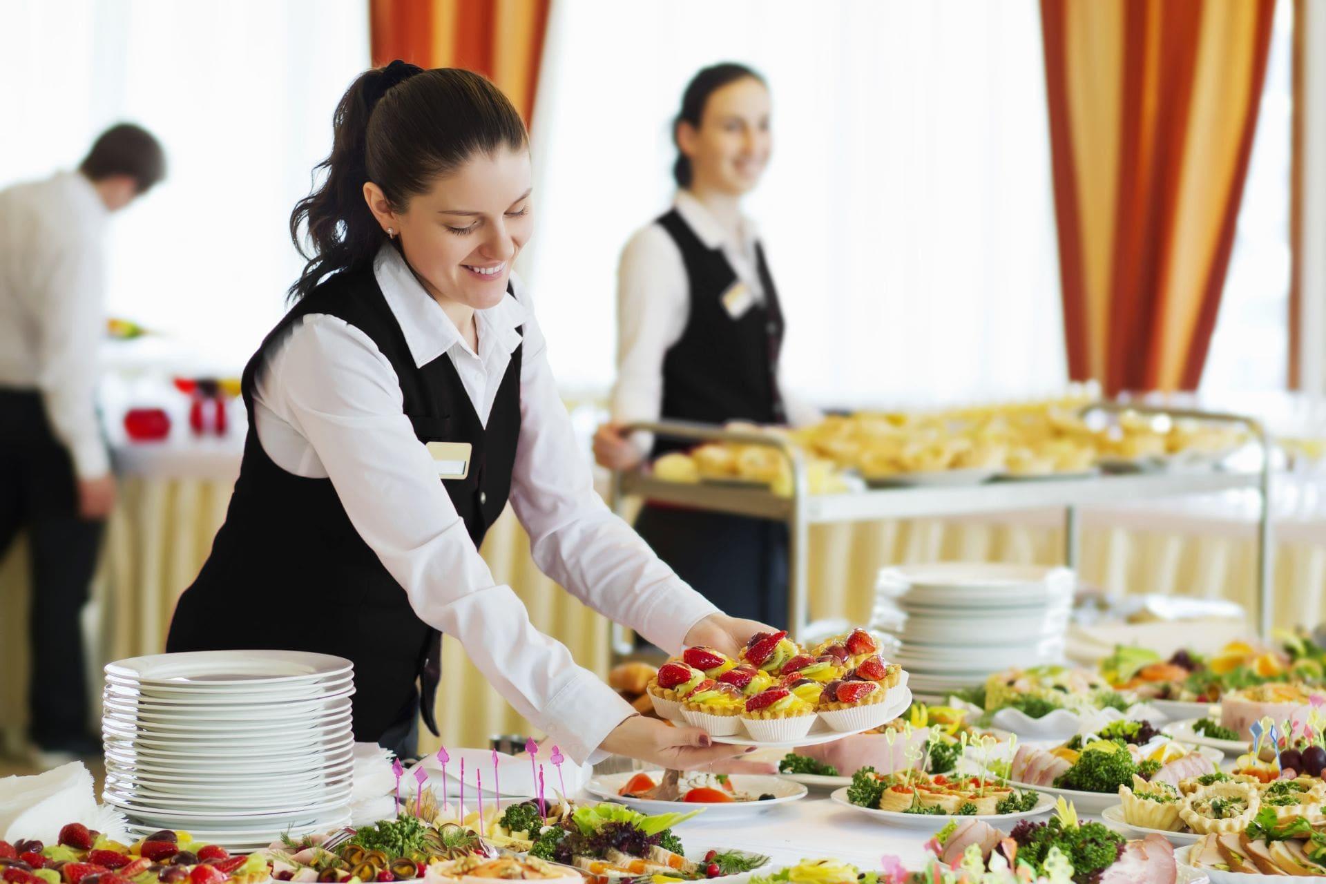 Waiters set the tables in the restaurant for the banquet